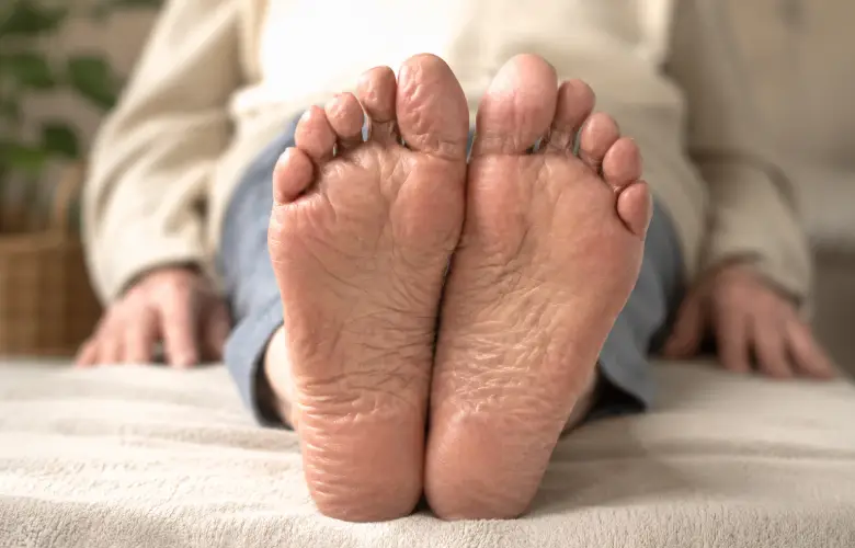 Pies de una persona mayor en una escena tranquila de bienestar y reflexología podal