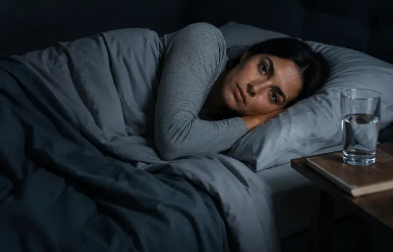 Persona despierta en la cama con la mente activa aunque está cansada